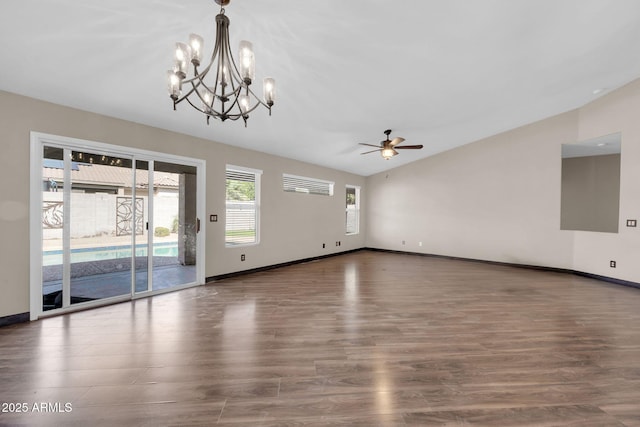 interior space with vaulted ceiling, ceiling fan with notable chandelier, wood finished floors, and baseboards