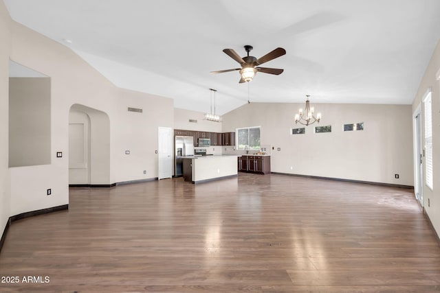 unfurnished living room with dark wood-style floors, arched walkways, visible vents, and ceiling fan with notable chandelier