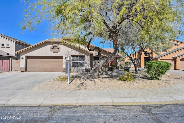 view of front of home with an attached garage, a tiled roof, concrete driveway, and stucco siding