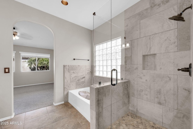 bathroom with tile patterned floors, a shower stall, baseboards, and a bath