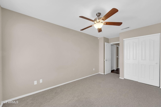 unfurnished bedroom featuring carpet floors, a closet, visible vents, a ceiling fan, and baseboards