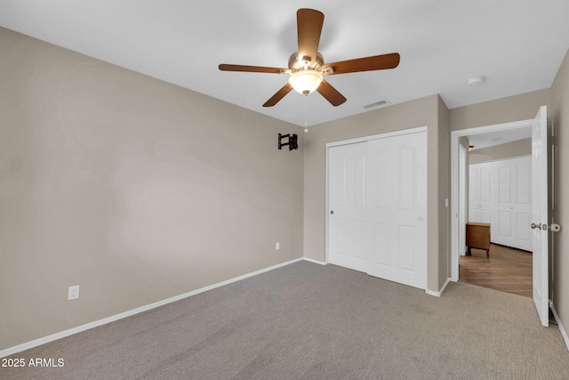 unfurnished bedroom featuring a closet, carpet flooring, visible vents, and baseboards