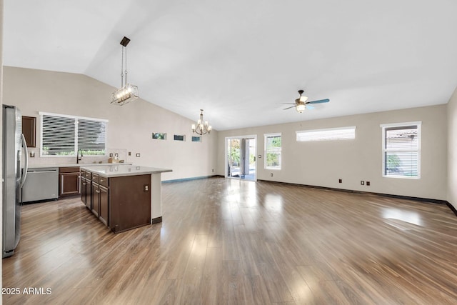 kitchen with open floor plan, stainless steel appliances, light countertops, and light wood-style floors