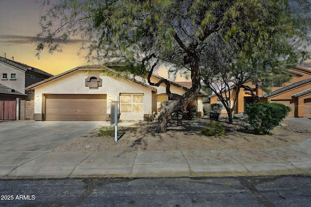 view of front facade featuring a garage, concrete driveway, and stucco siding