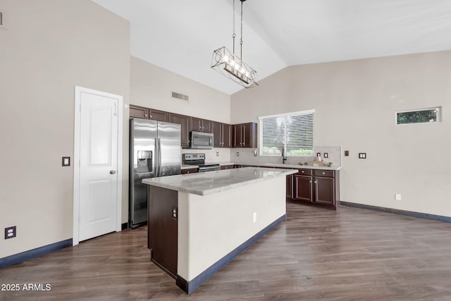 kitchen featuring stainless steel appliances, a kitchen island, visible vents, dark brown cabinets, and dark wood-style floors