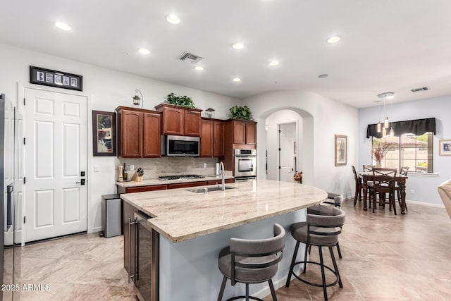 800 W Sycamore Ct, Litchfield Park, AZ 85340 - kitchen featuring a sink, stainless steel appliances, visible vents, arched walkways, and beverage cooler