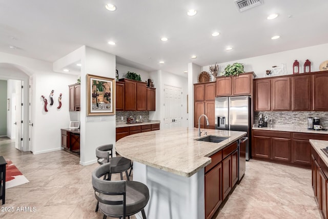 800 W Sycamore Ct, Litchfield Park, AZ 85340 - kitchen with a sink, a breakfast bar, visible vents, recessed lighting, and backsplash