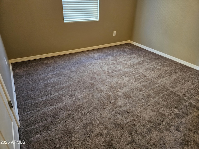 spare room featuring dark colored carpet