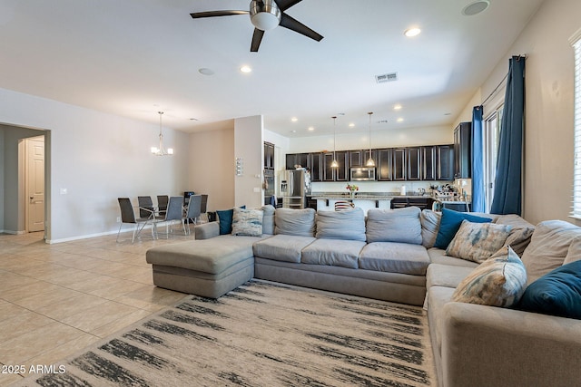 living area with light tile patterned floors, visible vents, recessed lighting, and ceiling fan with notable chandelier