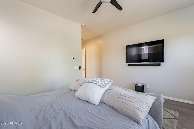 bedroom featuring baseboards, wood finished floors, and a ceiling fan