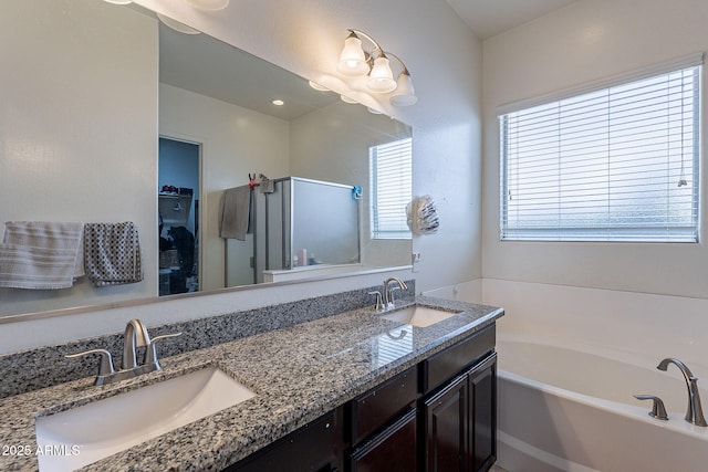 bathroom featuring double vanity, a sink, a garden tub, and a spacious closet