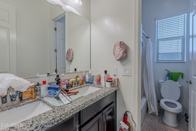 full bath with a sink, toilet, double vanity, and shower / bath combo