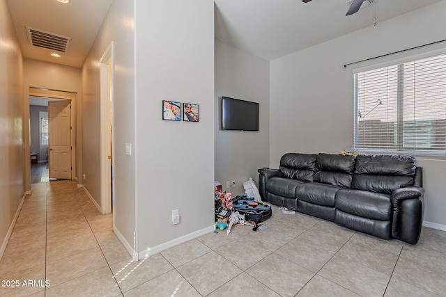living area featuring light tile patterned floors, baseboards, ceiling fan, and visible vents