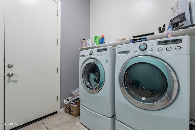 washroom featuring light tile patterned floors, washer and clothes dryer, and laundry area