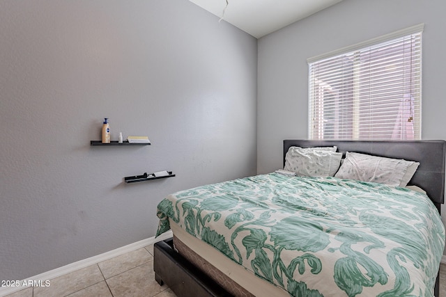 bedroom featuring light tile patterned floors and baseboards