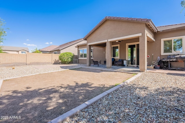 back of house with a patio, ceiling fan, a fenced backyard, a tile roof, and stucco siding
