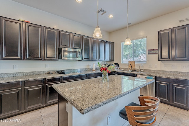 kitchen with light stone countertops, visible vents, stainless steel appliances, and light tile patterned floors