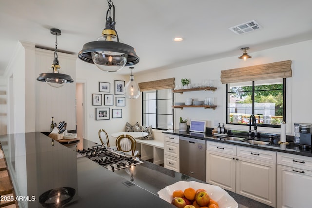 kitchen featuring a sink, dark countertops, visible vents, pendant lighting, and dishwasher