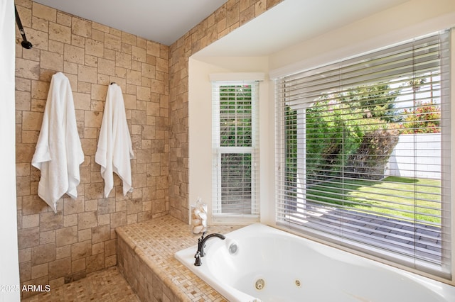 full bathroom with a tub with jets