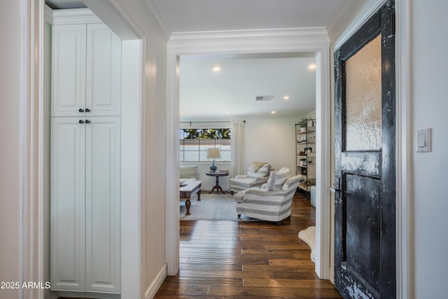 hall featuring crown molding, baseboards, visible vents, and dark wood finished floors