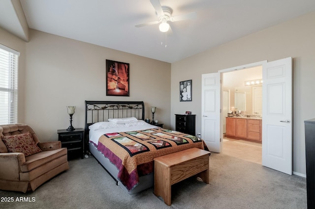 carpeted bedroom featuring ceiling fan and ensuite bath