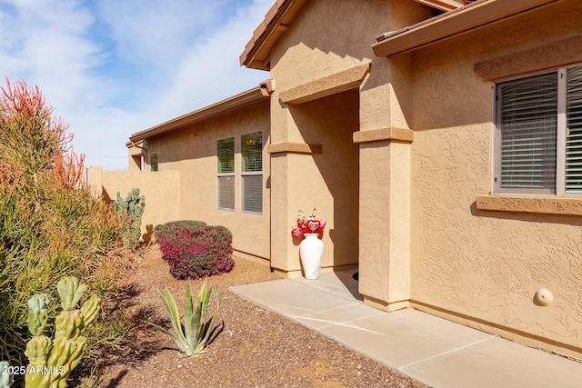 view of exterior entry with a patio area