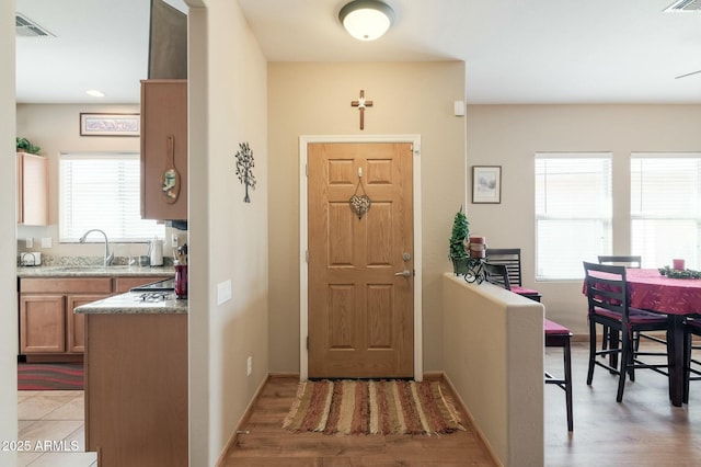 foyer entrance featuring sink and light hardwood / wood-style flooring