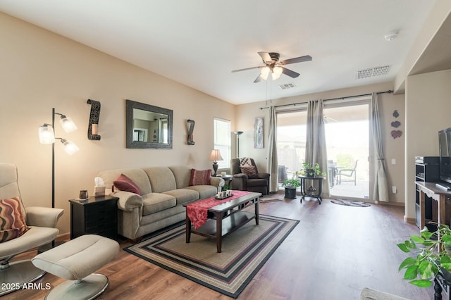 living room with ceiling fan, wood-type flooring, and a healthy amount of sunlight