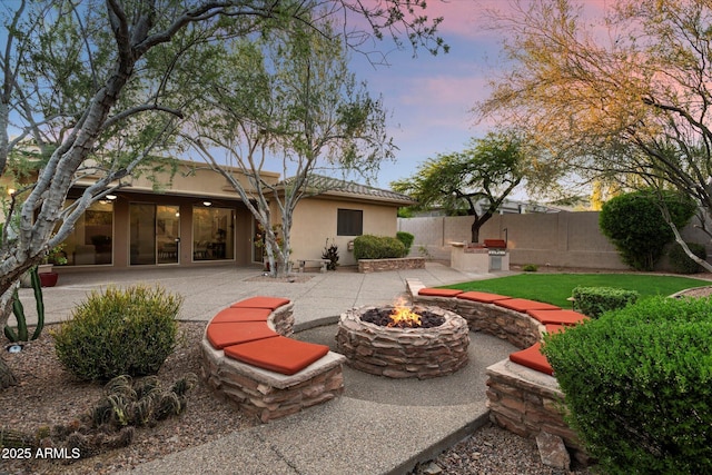 11193 N 121st Way, Scottsdale, AZ 85259 - back of property at dusk with an outdoor fire pit, a patio, and stucco siding