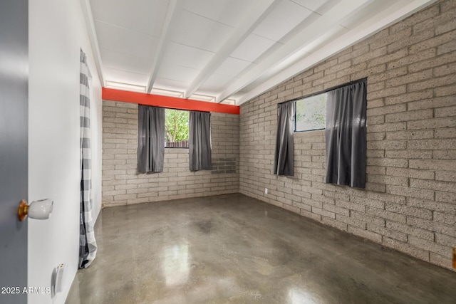 5739 N 11th St, Phoenix, AZ 85014 - unfurnished room with plenty of natural light, lofted ceiling, concrete floors, and brick wall