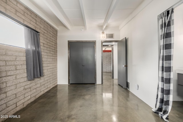 5739 N 11th St, Phoenix, AZ 85014 - spare room featuring finished concrete flooring, beamed ceiling, and brick wall