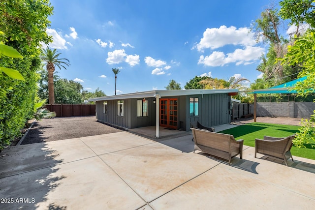 5739 N 11th St, Phoenix, AZ 85014 - back of property featuring board and batten siding, french doors, a patio, and a fenced backyard