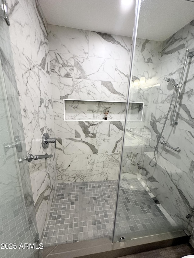 interior space featuring a marble finish shower