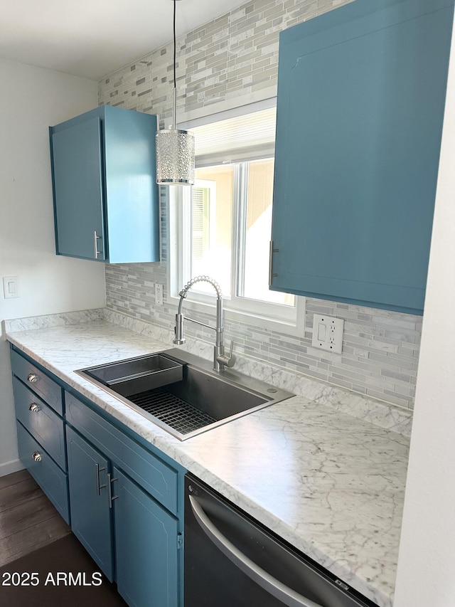 kitchen featuring dishwasher, a sink, light countertops, blue cabinetry, and backsplash