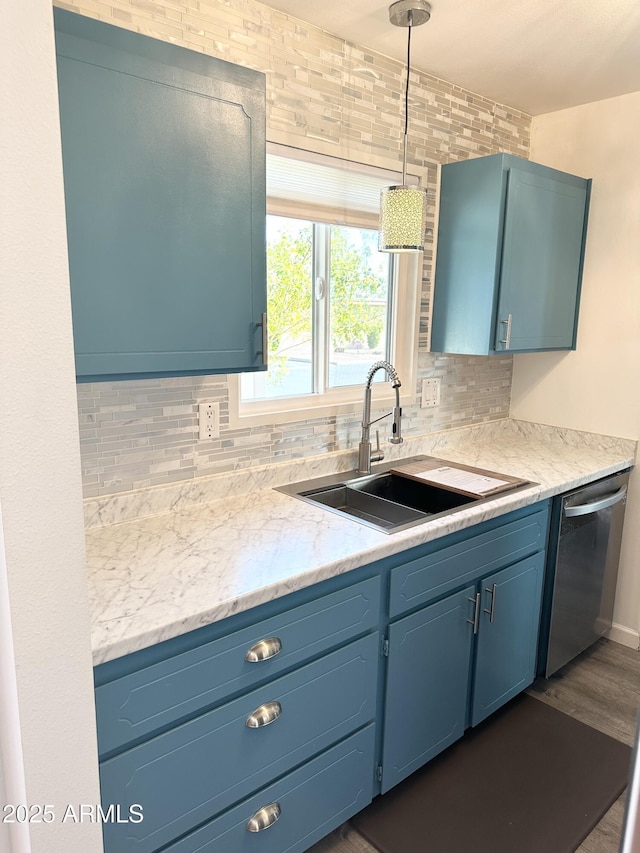 kitchen featuring dishwasher, blue cabinetry, a sink, and backsplash