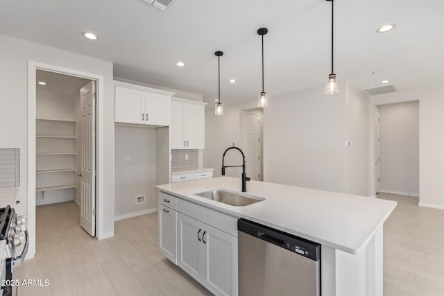 kitchen featuring white cabinets, appliances with stainless steel finishes, a kitchen island with sink, and sink