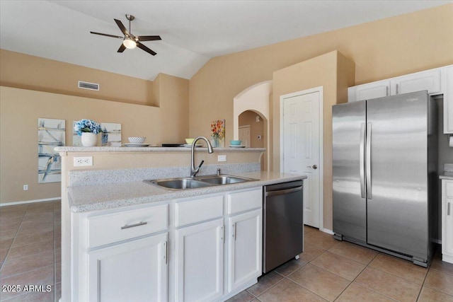4459 E Desert Wind Dr, Phoenix, AZ 85044 - kitchen with stainless steel appliances, light tile patterned floors, ceiling fan, arched walkways, and lofted ceiling