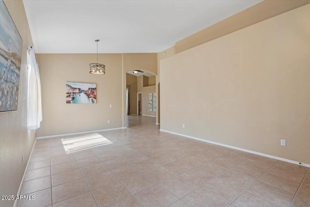 4459 E Desert Wind Dr, Phoenix, AZ 85044 - empty room featuring arched walkways, light tile patterned floors, vaulted ceiling, and a chandelier