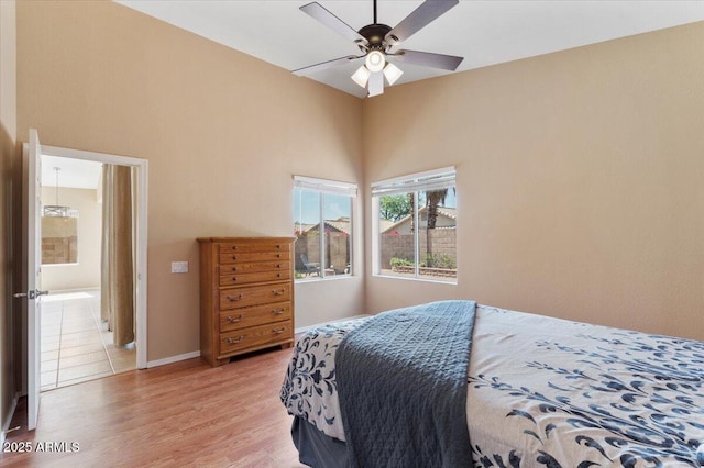 4459 E Desert Wind Dr, Phoenix, AZ 85044 - bedroom featuring light wood-style flooring, a ceiling fan, and a towering ceiling