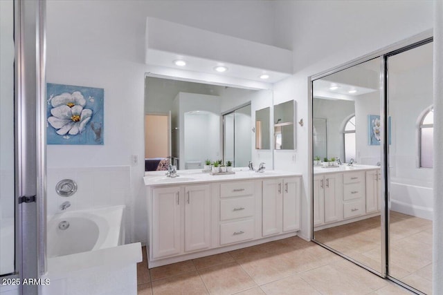 4459 E Desert Wind Dr, Phoenix, AZ 85044 - bathroom with a garden tub, double vanity, tile patterned flooring, and recessed lighting