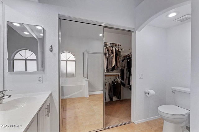 4459 E Desert Wind Dr, Phoenix, AZ 85044 - bathroom with tile patterned floors, vanity, a walk in closet, and a garden tub