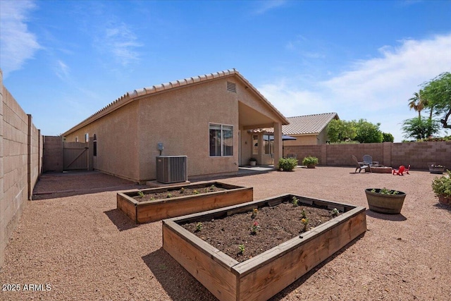 4459 E Desert Wind Dr, Phoenix, AZ 85044 - back of house with a gate, a vegetable garden, a fenced backyard, and stucco siding
