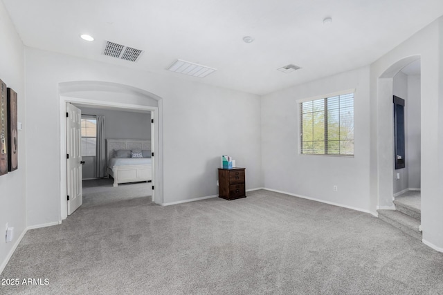 empty room with light carpet, visible vents, and baseboards