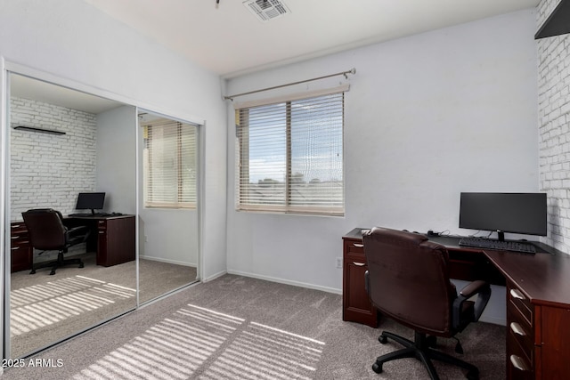 office area featuring brick wall, visible vents, light carpet, and baseboards