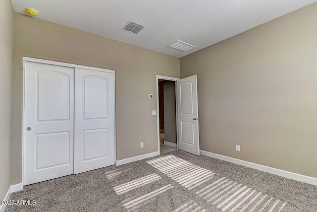 unfurnished bedroom featuring a closet, carpet, visible vents, and baseboards