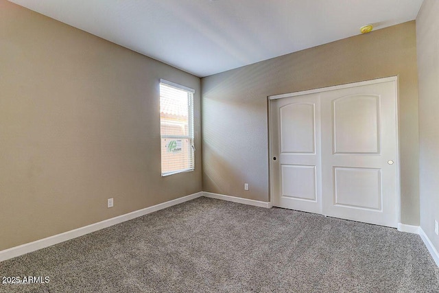 unfurnished bedroom with carpet floors, a closet, and baseboards