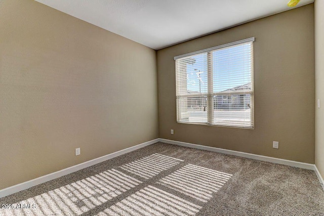 carpeted spare room featuring baseboards