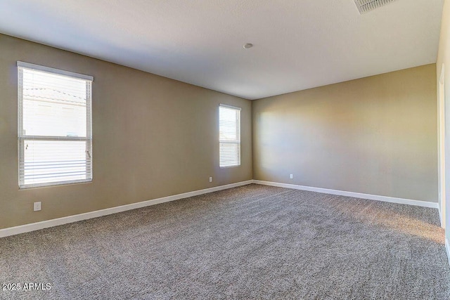 carpeted empty room featuring visible vents and baseboards