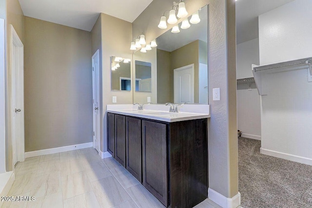 full bathroom featuring double vanity, baseboards, and a sink