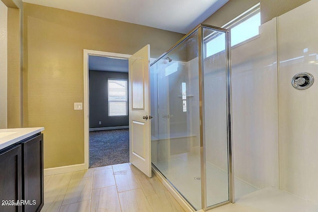 full bath with a shower stall, baseboards, and vanity